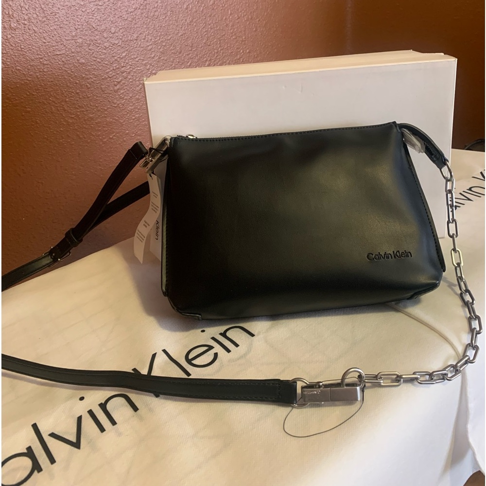 CK crossbody bag has adjustable straps and a zipper closure